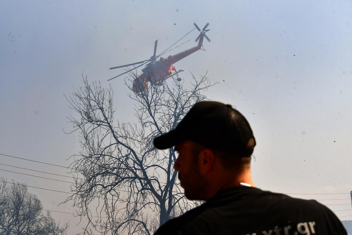 Metochi (Greece), 23/07/2023.- A firefighting aircraft drops water to extinguish a wildfire at Metochi village, near Epidaurus, Greece, 23 July 2023. There is an extreme, category 5, fire risk high alert also for 24 July, for five Greek regions of Attica, Central Greece, the Peloponnese, Western Greece and southern Aegean with the island of Rhodes, according to the Fire Risk Forecast Map issued by the General Secretariat for Civil Protection at the climate crisis and civil protection ministry. (incendio forestal, Grecia) EFE/EPA/BOUGIOTIS EVANGELOS
