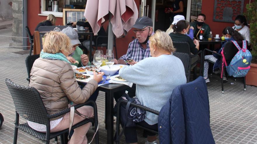 Diverses persones a les taules d&#039;una terrassa de bar de la plaça de Santa Maria de Puigcerdà