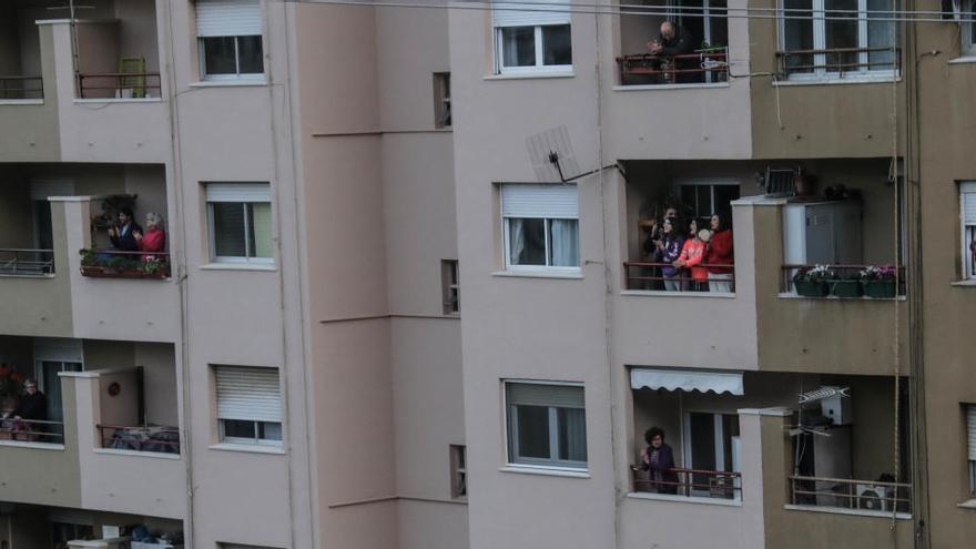 Vecinos asomados a las ventanas en pleno confinamiento