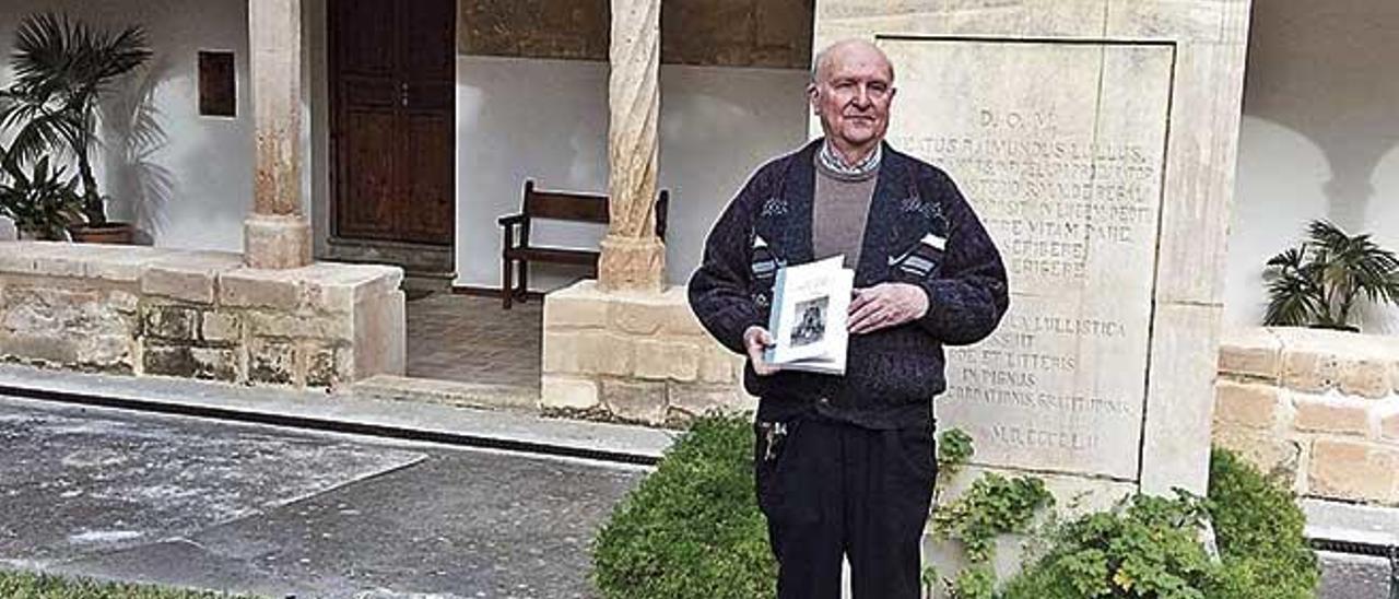 El padre Josep Amengual Batle posa en el claustro del Monasterio de La Real con el libro.