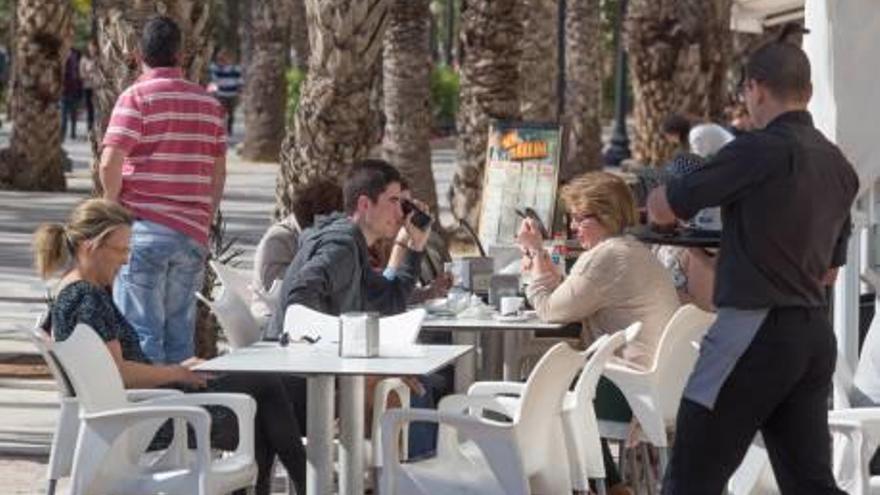 Una pareja disfruta dle sol en una terraza, ayer