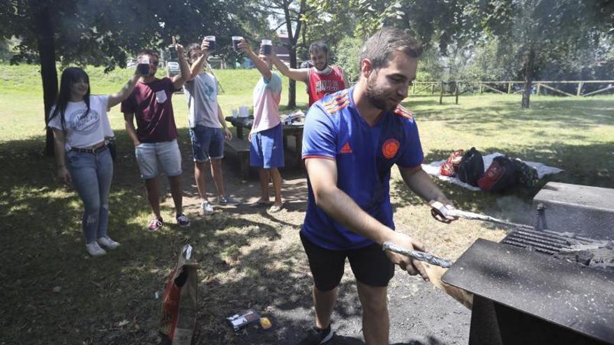 Sheila Álvarez, Jorge Abelleira, Javier García, Samuel Pérez y Yoel Zamora brindan mientras David Fraga atiende la parrilla.