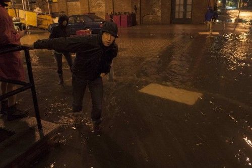 Un hombre mira por una calle inundada en el barrio DUMBO de Brooklyn