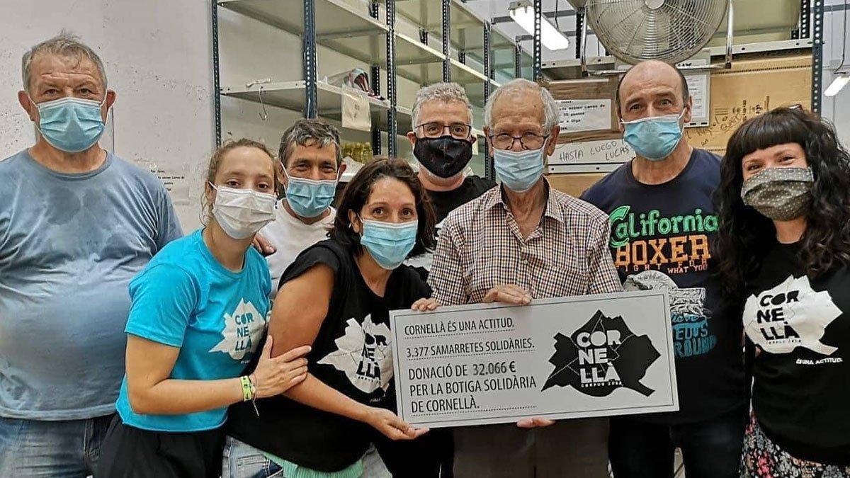 Representantes y voluntarios del Banc d'aliments de Cornellà con representantes de Cornellà Actitud haciendo entrega de la donación para la recaptación solidaria al Corpus 2020.