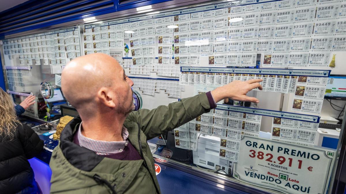 Un comprador elige décimo para el sorteo del Niño en la administración de lotería de Las Arenas, en Barcelona.