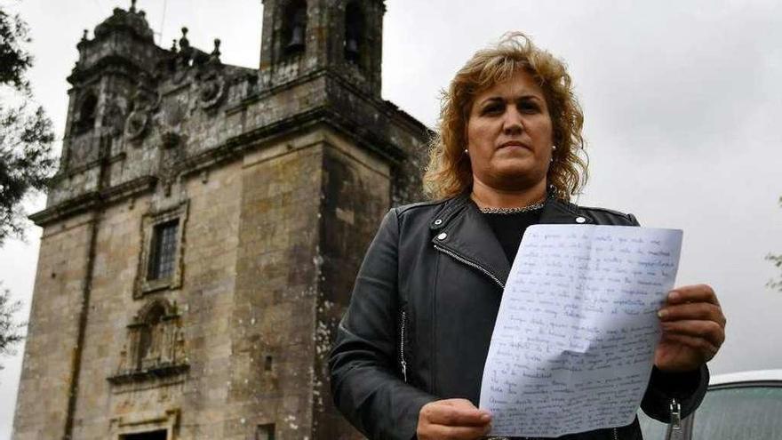 Rocío Novegil muestra la carta a su padre, ante la iglesia de San Benito de Lérez. // G. Santos