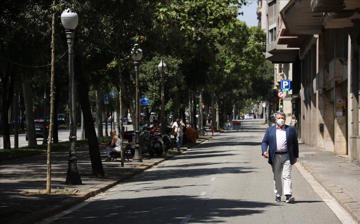 Un hombre anda por la Diagonal de Barcelona.