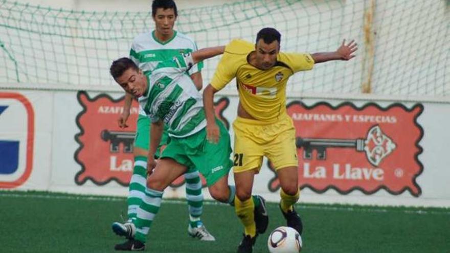 Juande protege el balón ante la presión de Adrián.