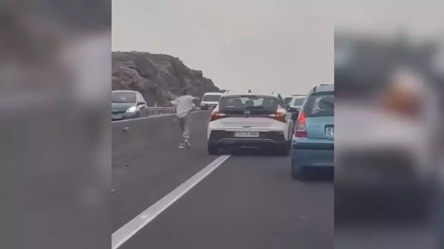 Una mujer se baja del coche y discute con su pareja en una cola en Tenerife