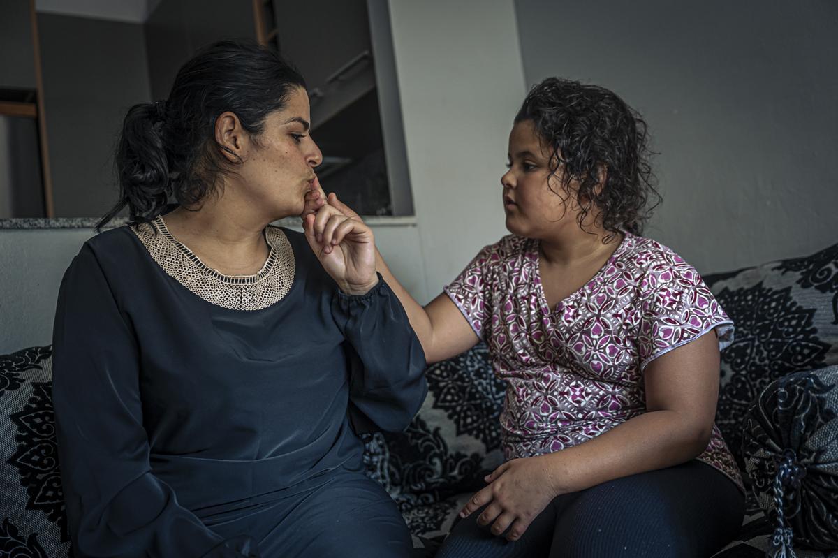 Reportaje de un bloque de pisos donde viven familias vulnerables que Endesa se los cortó la luz lo el pasado viernes y hasta ahora no tienen. Sara Badani y su hija autista de tercer grado, Doha, sentadas en el sofá de su casa.