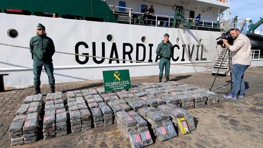 Dos agentes, junto a los fardos con los 725 kilos de cocaína intervenidos al velero &#039;Adamas&#039;, ayer, en el Arsenal.