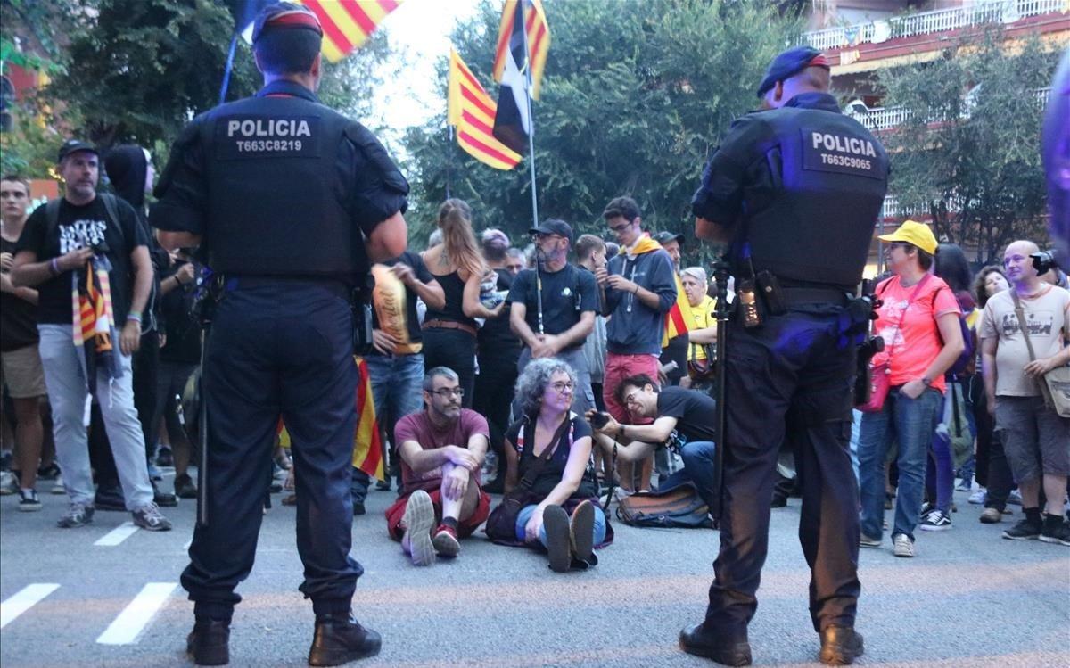 Dos agents dels Mossos d’Esquadra, davant d’un grup de persones d’ideologia independentista concentrades a la caserna de la Guàrdia Civil de Travessera de Gràcia a Barcelona, el 20 de setembre passat.