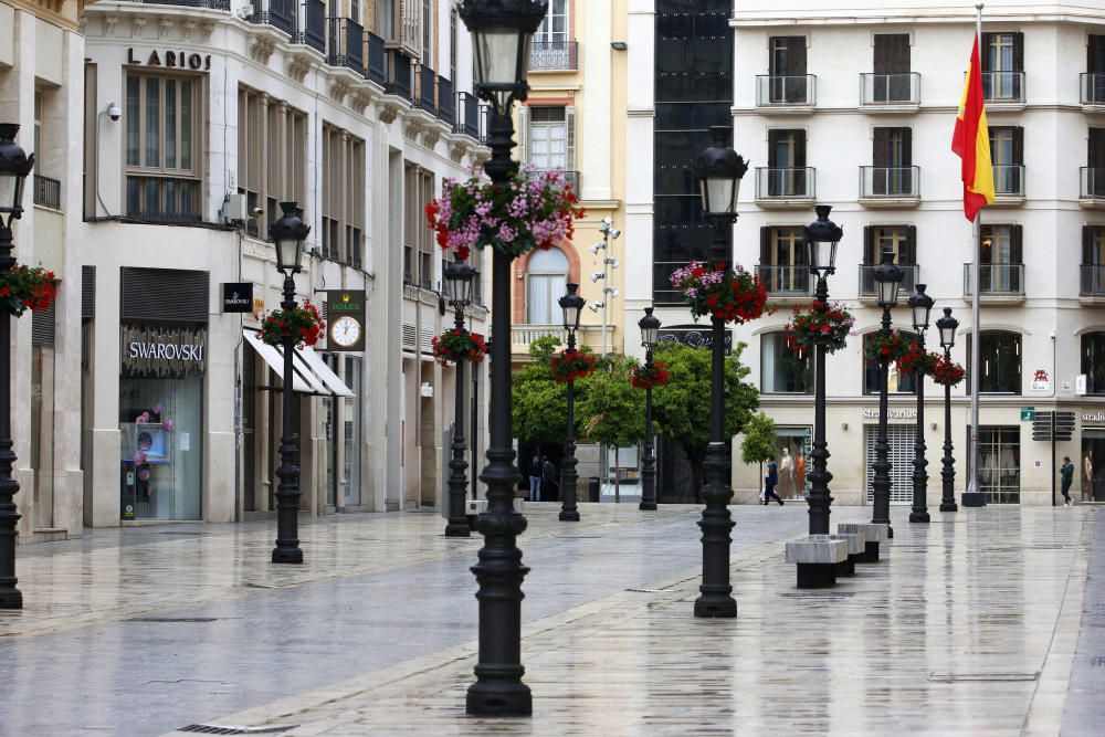 Pasan los días de confinamiento y la situación de la ciudad sigue siendo desértica. La siempre frecuentada calle Larios, la Alameda, principal vía de tráfico tanto privado como público del centro de la ciudad, y el bullicioso mercado de Atarazanas presentan durante el estado de alarma provocado por la pandemia de coronavirus una imagen inusual, acentuada por la persistente lluvia de esta semana.