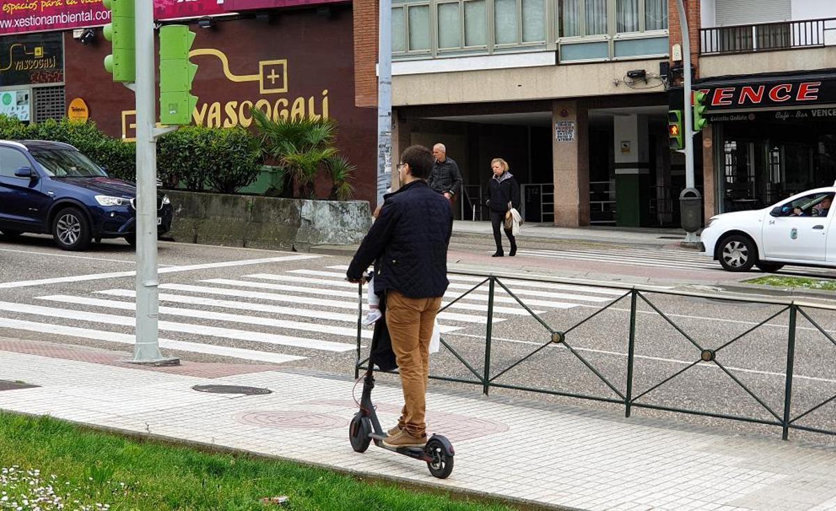 Un usuario de patinete eléctrico circulando por la acera en Isaac Peral. // Marta G. Brea