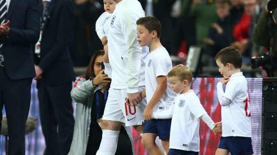 Rooney salta al campo con sus cuatro hijos. // Efe