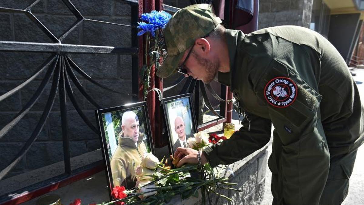 Un seguidor de Wagner endiende una vela ante los retratos del dueño, Yevgeni Prigozhin, y su lugarteniente, Dmitri Utkin, el 24 de agosto en Novosibirsk (Rusia).