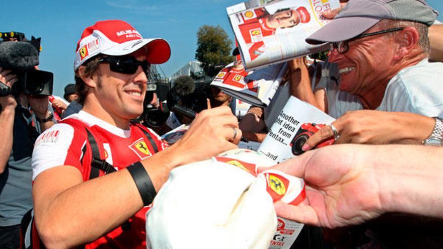 El piloto español de Fórmula Uno Fernando Alonso, de Ferrari, firma autógrafos a su llegada al &quot;paddock&quot; del circuito Albert Park de Melbourne (Australia).