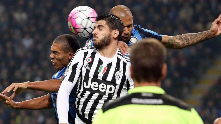Morata cabecea el balón entre dos rivales del Inter durante el partido de ayer. // Daniel Dal Zennaro