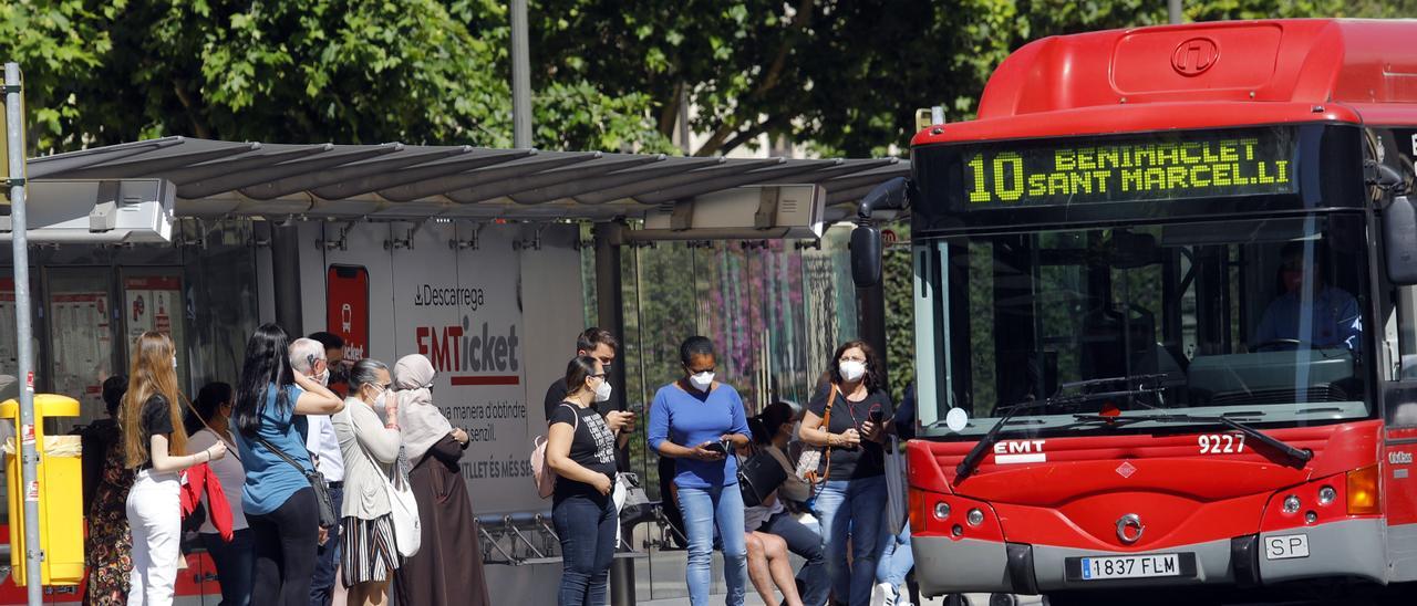 Un grup de viatgers espera per a accedir al bus de la línia 10.