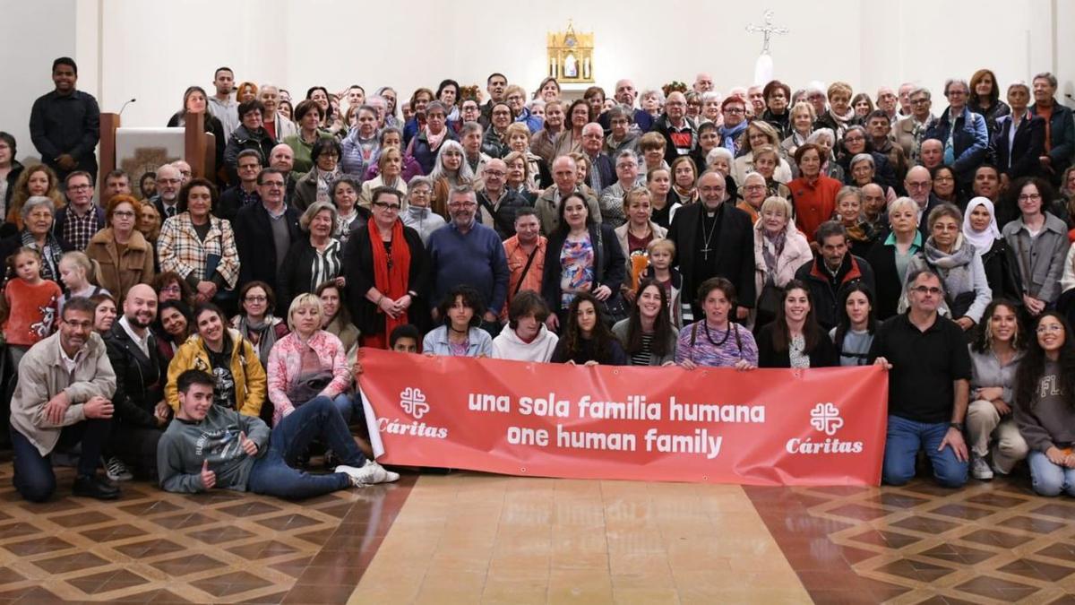 Trabajadores, socios y colaboradores de Cáritas Diocesana de Oviedo posan en la capilla del Seminario con el arzobispo de Oviedo, ayer. | Cáritas