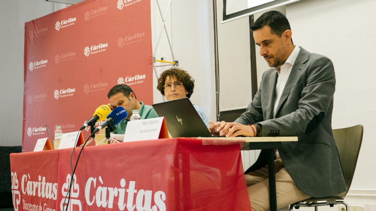 El responsable d&#039;acció social de Càritas Girona, Caye Gómez; la directora de l&#039;entitat, Dolors Puigdevall, i el secretari general, Martí Batllori, durant la presentació de la memòria del 2021