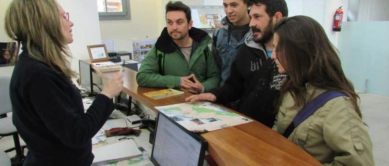 Susana González, ayer, enseñando un plano de Llanes a los turistas Miguel Domenech, Jaime Rodríguez, Ayman Bourezeg y Eva Alférez.