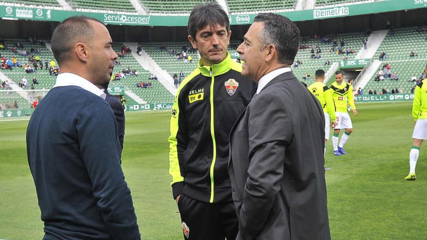 Jorge Cordero, Pacheta y Diego García dialogan antes de un partido en el Martínez Valero.