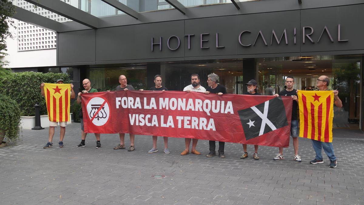 La façana de l'hotel Camiral amb diversos membres de la coordinadora antimonàrquica amb una pancarta en contra de la presència dels reis d'Espanya