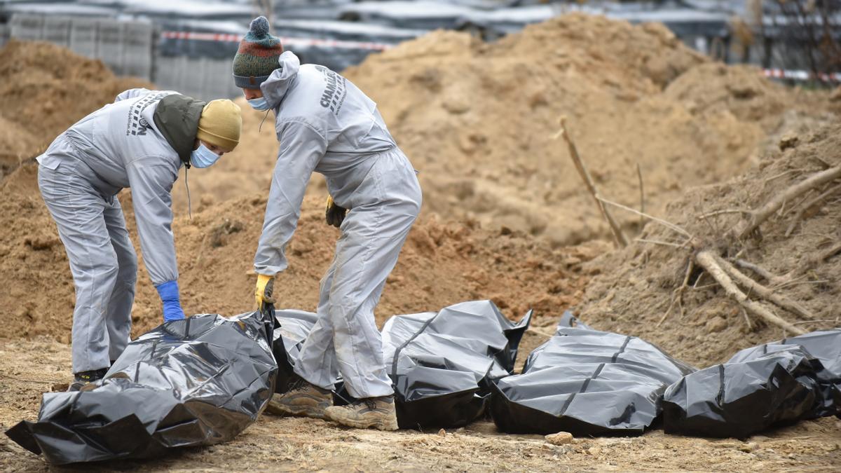 Trabajador exhuma cuerpos de la fosa común cerca de la Iglesia de San Andrés y Todos los Santos en la ciudad de Bucha en Kiev
