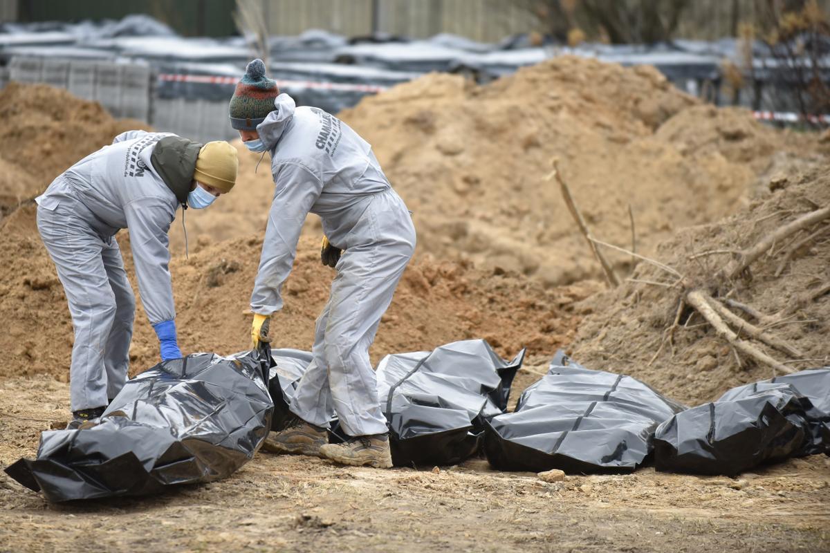 Trabajador exhuma cuerpos de la fosa común cerca de la Iglesia de San Andrés y Todos los Santos en la ciudad de Bucha en Kiev