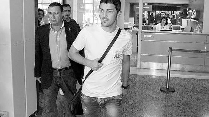 David Villa, con su representante, José Luis Tamargo, a la izquierda, en el aeropuerto de Asturias el pasado lunes.