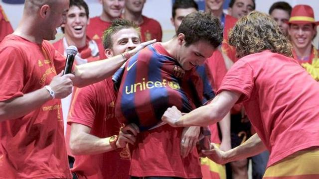 Los jugadores de la selección española de fútbol ponen una camiseta del FC Barcelona a Cesc Fábregas (2-d), durante la celebración en el Puente del Rey, en Madrid, por la victoria en el Campeonato del Mundo de Sudáfrica 2010.