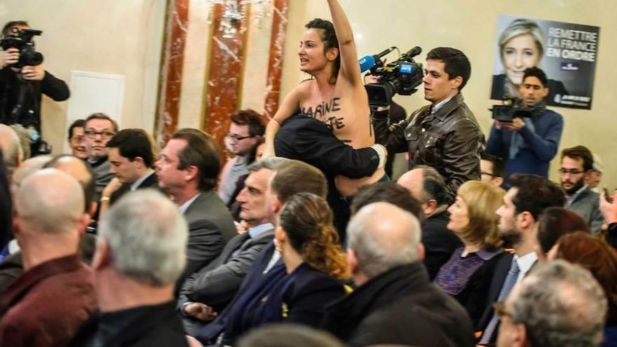 Una militante de Femen interrumpe un acto de Le Pen en París.