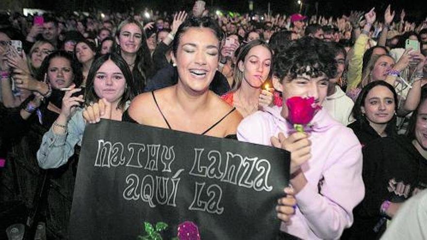Dos espectadoras reclaman una rosa a Nathy Peluso con una pancarta, objetivo que lograron en Llanera. | María Fuentes