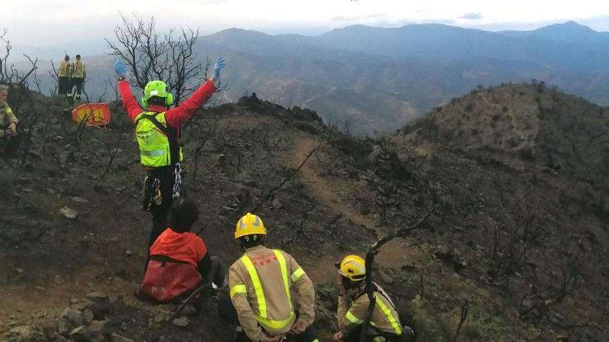 Els efectius dels Bombers atenent la dona ferida i fent senyals a l&#039;helicòpter del GRAE