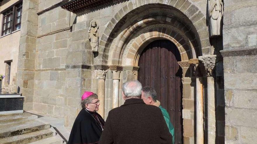 El obispo de Astorga conversa con dos vecinos en una visita a la provincia.