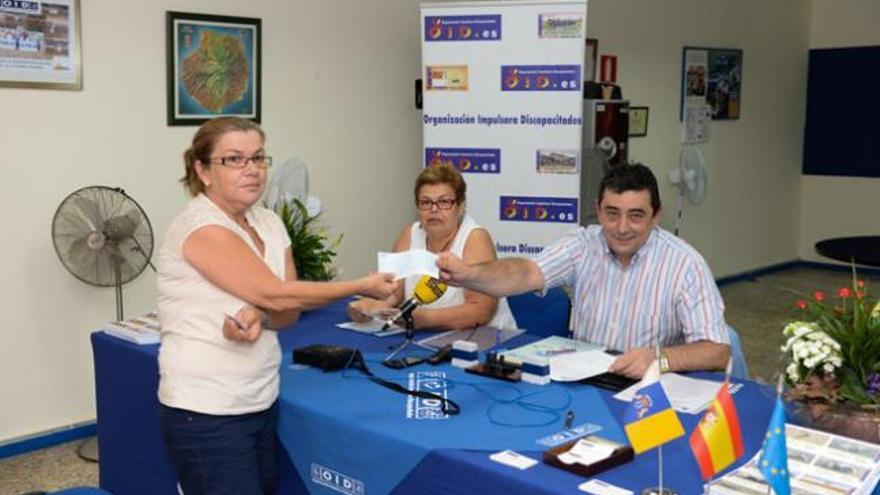 Carlos Vicente Salas entrega un cheque a María del Carmen Martín. Sentada, María de la Cruz Rodríguez. | josé carlos guerra