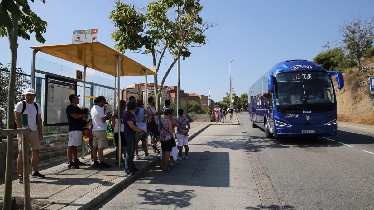 Aglomeraciones de turistas en buses y paradas cercanas a una entrada del Park Güell.