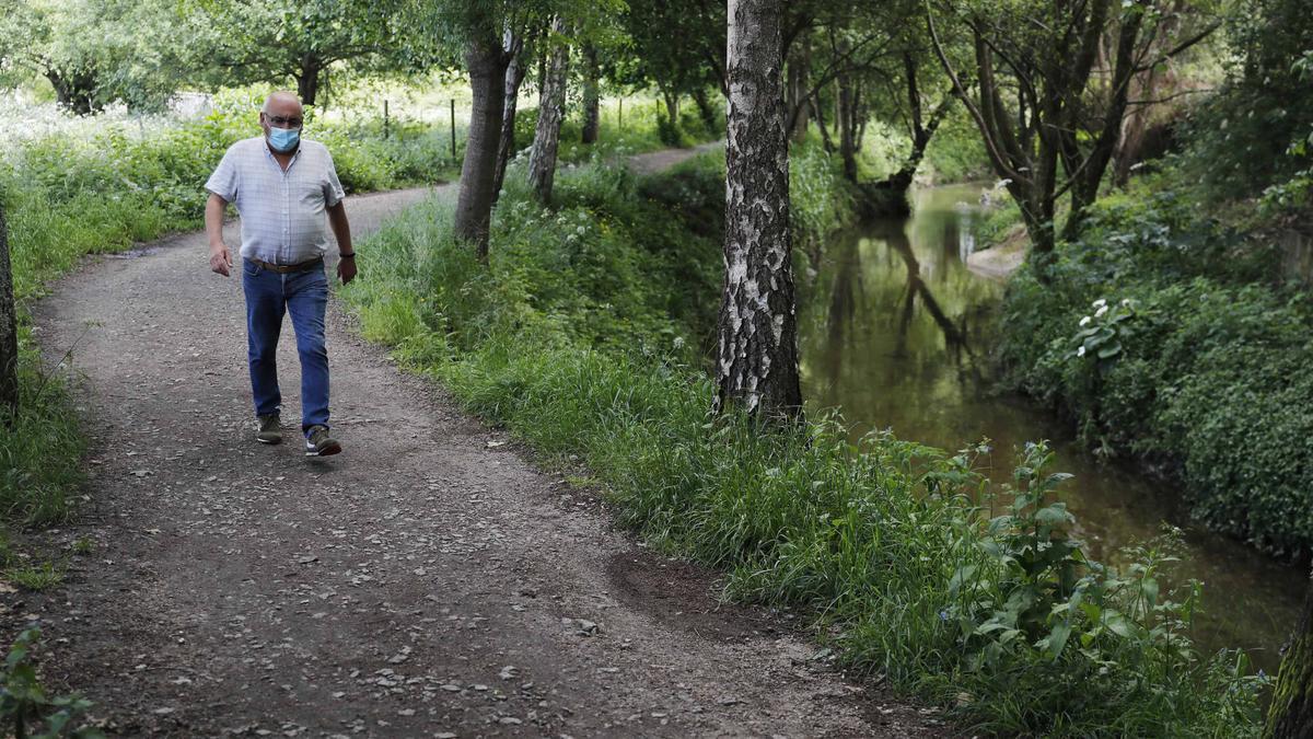 Un senderista paseando por el margen del río Lagares.