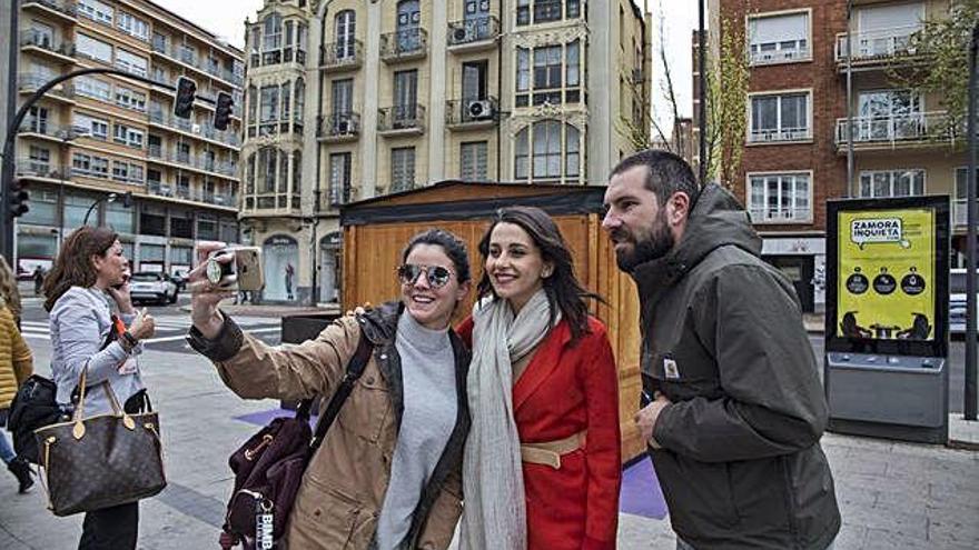 Dos jóvenes se hacen una foto en la zona de la Marina junto a Inés Arrimadas.