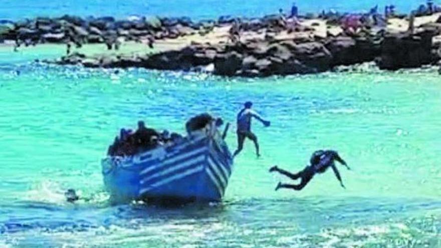 Migrantes saltan de la patera al llegar este martes, por sus propios medios, a la playa de El Jablillo, en Lanzarote.