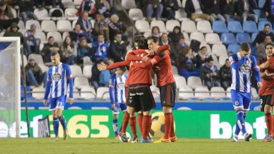 Los jugadores del Mirandés festejan uno de los goles ante el abatimiento de los jugadores coruñeses. // 13fotos