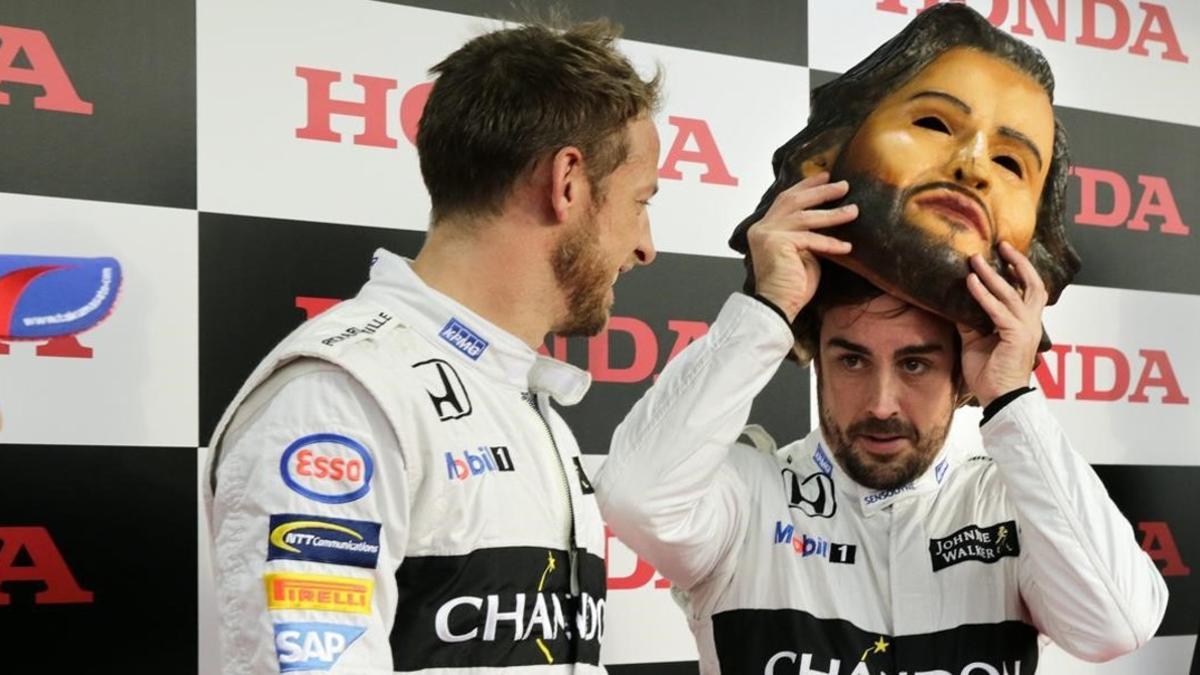 Fernando Alonso se coloca una máscara de sí mismo junto a Jenson Button durante la fiesta de fin de temporada de Honda en Motegi.