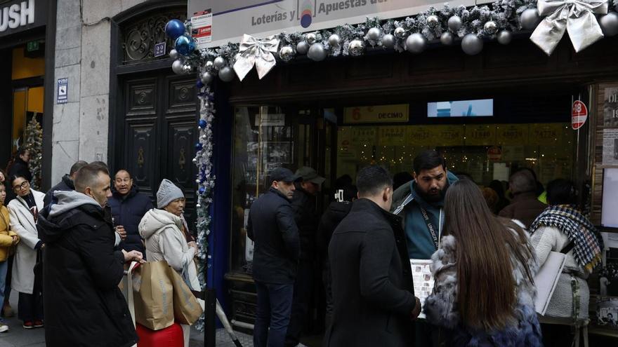 Varias personas hacen cola en una administración de Lotería.