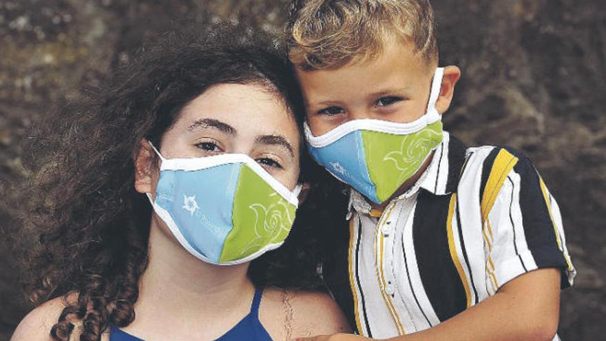 Unos niños con las mascarillas que ha adquirido el consistorio.