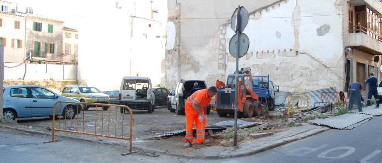 Varios operarios llevan a cabo obras de adecentamiento del aparcamiento de la calle Bisbe Cima.