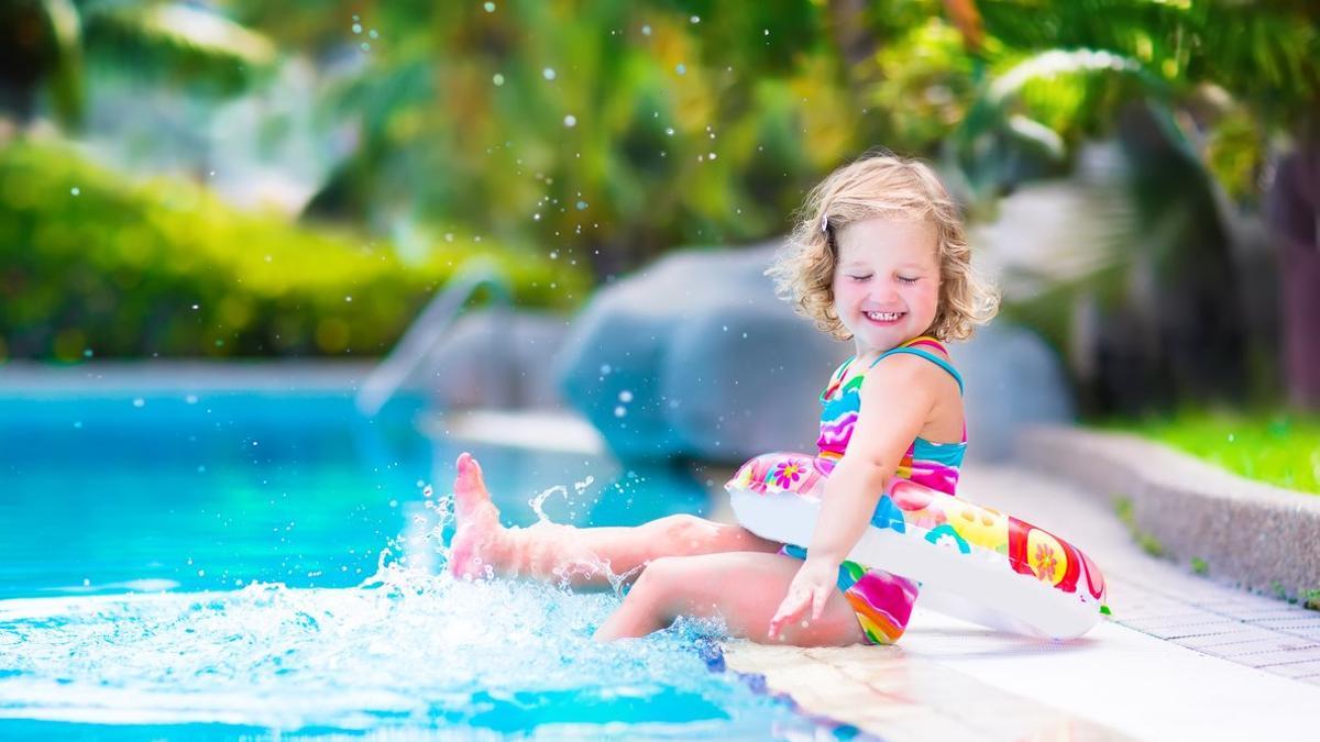 Una niña pequeña jugando en la piscina