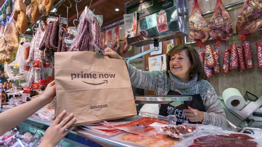 Una vendedora del Mercado Central entrega una compra de Amazon.