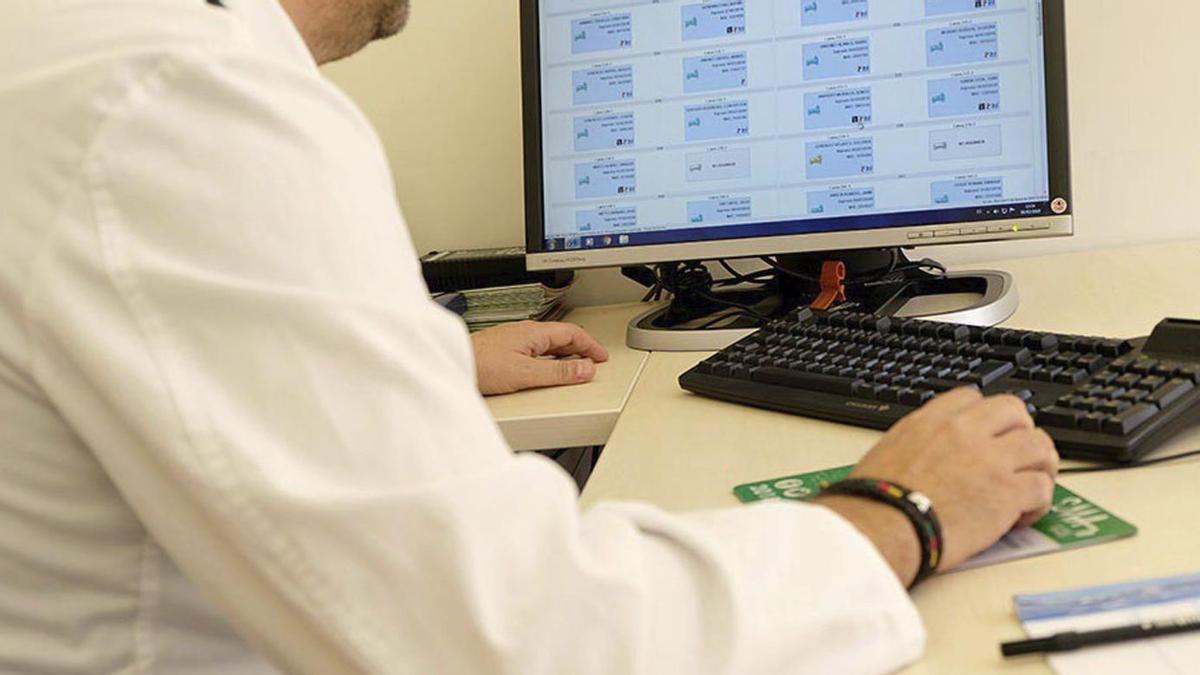 Un médico revisa informes en su ordenador en la consulta. | ARCHIVO