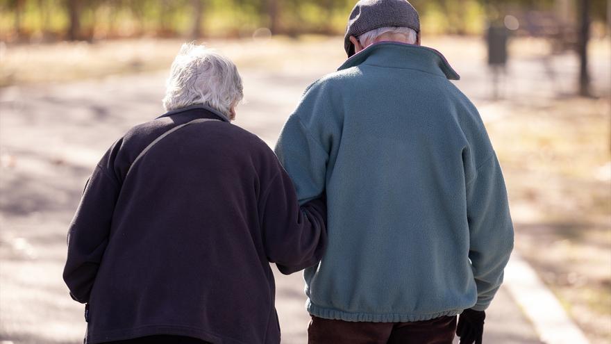 Dos personas mayores caminan por la calle